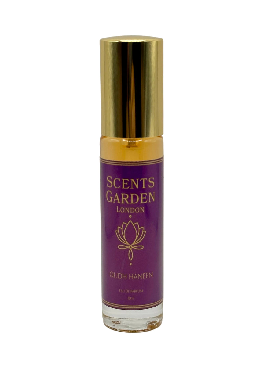 A spray bottle of Scents Garden Oudh Haneen perfume with a purple label and green liquid inside.